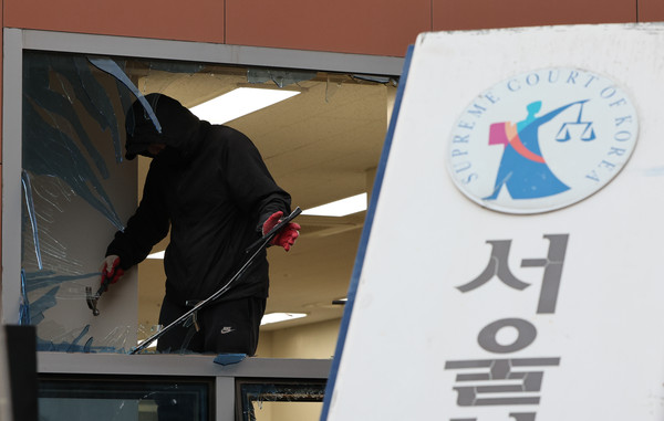 ▲ 지난 1월19일 오후 서울 마포구 서울서부지방법원에서 작업자들이 윤석열 대통령 지지자들의 난입으로 파손된 시설들을 청소하고 있다. /뉴시스