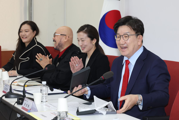 ▲ 권성동 국민의힘 원내대표가 25일 서울 여의도 국회에서 열린 패션산업 지원 정책간담회에서 이상봉 이상봉 대표가 선물한 빨간 넥타이를 바로 착용한 뒤 웃음짓고 있다. /뉴시스