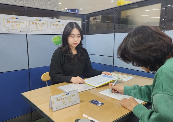 ▲ 황금도시락 사업 대상자가 광명사랑화폐 카드를 지급받고, 1인가구 식생활실태 사전조사서를 작성하고 있다.