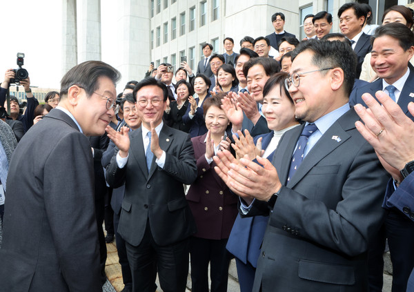 ▲ 이재명 더불어민주당 전 대표가 대표직 사퇴 후 박찬대 원내대표와 최고위원 등 의원들과 기념촬영을 하고 국회를 나서며 박수를 받고 있다. /뉴시스