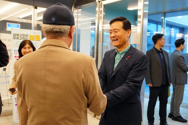 ▲ 전입신고를 위해 장위3동 주민센터를 방문한 장위 자이레디언트 주민에게 환영의 인사를 건네는 이승로 성북구청장(오른쪽).