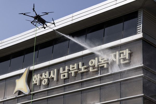 ▲ 화성특례시 관내기업 실증지원사업 제1호 기업인 (주)DRT가 외벽 청소용 드론을 활용해 화성시남부노인복지관 외벽을 청소하며 기술을 실증해 보고 있다.