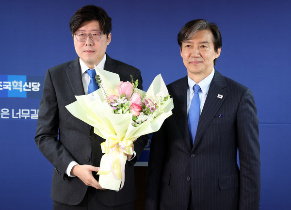 ▲ 지난해 3월 11일 서울 여의도 조국혁신당 당사에서 열린 전문가 입당식에서 조국 조국혁신당 당시 대표에게 꽃다발을 받은 후 기념촬영을 하는 이 전 검사 모습. /뉴시스