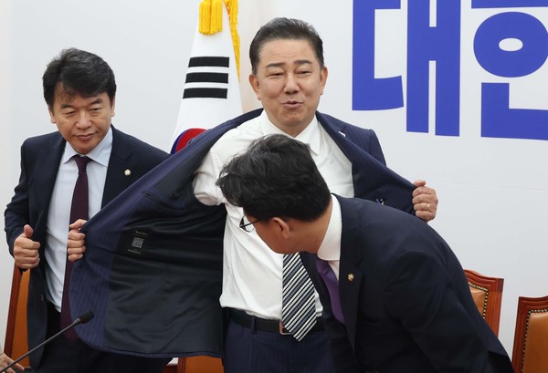 ▲ 김병기 더불어민주당 당대표 직무대행 겸 원내대표가 17일 오전 서울 여의도 국회에서 열린 원내대책회의에 앞서 외투를 벗고 있다. /뉴시스