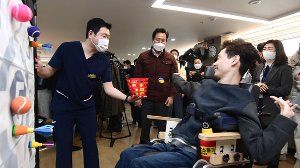 ▲ 오세훈 서울시장이 지난 2023년 2월1일 서울 강동구 중증뇌병변장애인 긴급수시돌봄 한아름 단기거주시설을 방문해 김우솔 씨가 손근육 재활운동하는 모습을 살펴보고 있는 모습. /뉴시스