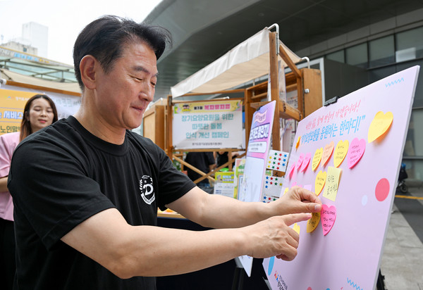 ▲ 김동근 시장이 ‘제3회 복지뮤지엄’ 행사에서 장기요양요원들을 응원하는 메모를 부착하고 있다.