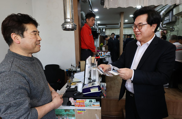 ▲ 박일하 동작구청장(오른쪽)이 지난 4월 신대방1동 온누리길 골목형 상점가에서 온누리상품권을 사용하고 있다.