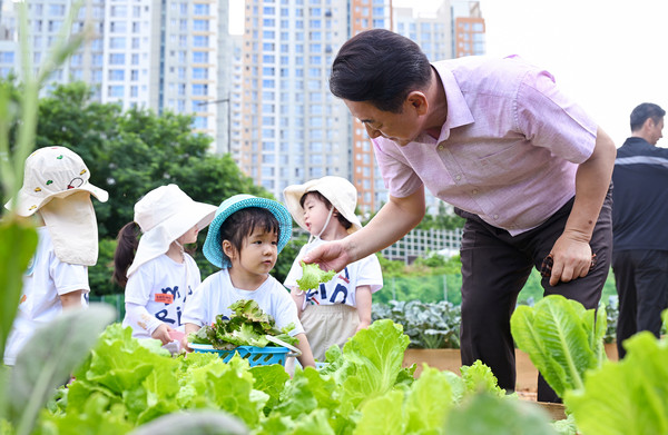 ▲ 김동근 시장이 ‘민락(民樂) 힐링 텃밭정원’을 방문해 어린이집 아동들과 함께 수확 체험을 하고 있다.