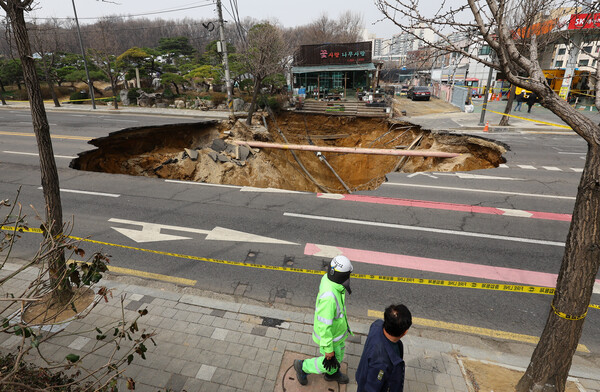 ▲ 지난 3월25일 서울 강동구 명일초등학교 인근 도로에서 전날 발생한 싱크홀(땅 꺼짐) 사고 현장 모습. /뉴시스