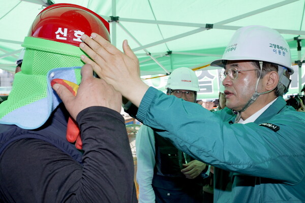 ▲ 이동환 고양특례시장이 근로자에게 차광막이 달린 안전모를 직접 씌어주고 있다.