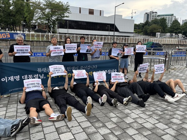 ▲ 1일 서울 용산 대통령실 앞에서 열린 온라인 플랫폼법 제정 촉구 기자회견에서 시민사회단체 회원들이 바닥에 누워 수수료 인상과 약관 불공정 문제를 규탄하는 퍼포먼스를 하고 있다. /뉴시스
