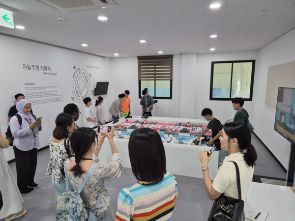 ▲ APEC 문화고위급대화로 방한한 외신 기자들이 성동 AI·미래기술체험센터를 방문해초등학생 대상으로 진행된 ‘AI 로봇리그’ 프로그램을 참관 중인 모습.