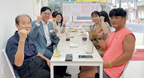▲ 이용욱 의원(사진 왼쪽에서 가운데)과 임유진 대표(오른쪽 뒷줄) 등이 단디한입 메뉴를 들고 기념 촬영을 했다.