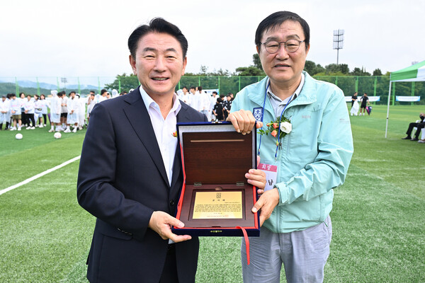 ▲ 김동근 시장(왼쪽)이 ‘녹양보조축구장’ 준공식에서 의정부시 축구협회로부터 감사패를 받은 뒤 기념사진을 찍고 있다.