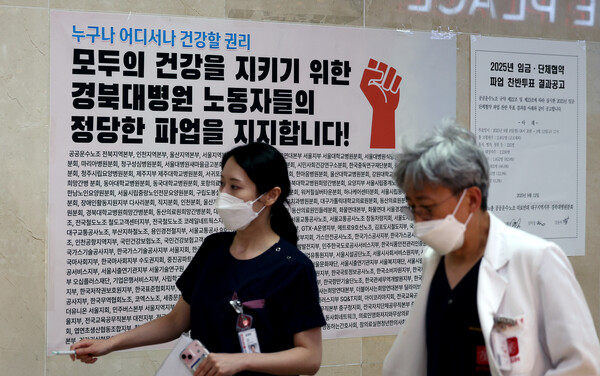 ▲ 9월 17일 대구 중구 경북대학교 병원 복도에 붙은 공공운수노조 의료연대본부 대자보 앞으로 의료진들이 이동하는 모습. /뉴시스