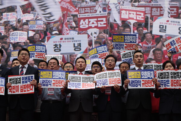 ▲ 장동혁 국민의힘 대표와 송언석 원내대표를 비롯한 의원들이 28일 서울 중구 대한문 앞에서 열린 국민의힘 주최 ‘사법파괴 입법독재 국민 규탄대회’ 에서 무대위에 올라 손피켓을 들고 구호를 외치고 있다. /뉴시스