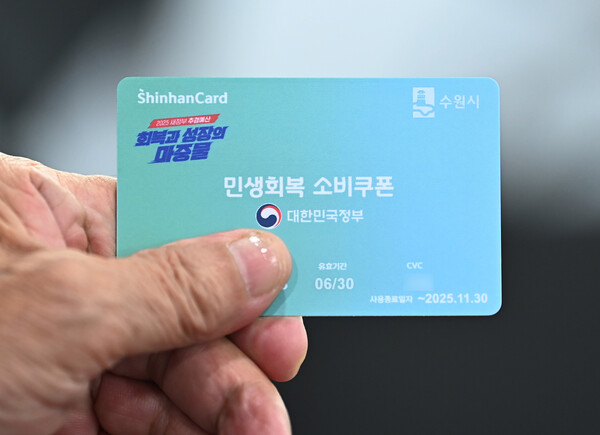 ▲ 민생회복 소비쿠폰 2차 신청이 시작된 지난 9월 22일 경기 수원시 팔달구 인계동행정복지센터에서 한 시민이 선불카드를 수령받고 있다. /뉴시스