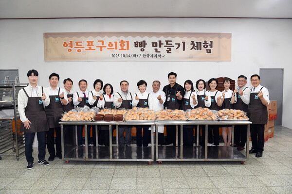 ▲ 정선희 의장을 비롯한 영등포구의회 의원들과 한국제과학교 김영석 이사장(가운데)이 완성한 빵 앞에서 기념촬영을 하고 있다