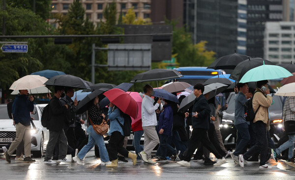 ▲ 전국 대부분 지역에 비가 내린 지난 10월 13일 서울 종로구 세종대로 사거리에서 우산을 쓴 시민들이 발걸음을 옮기고 있다. /뉴시스