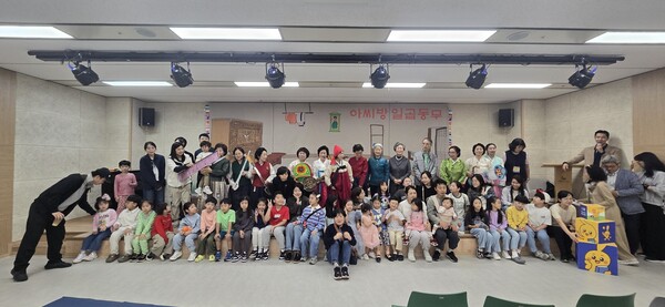 ▲ ‘모두 함께! 이야기 마당극’을 주제로 책 읽어주는 할머니, 전래동요, 수수께끼 등 전통 공연과 북버스킹 참여자들 기념촬영 모습.