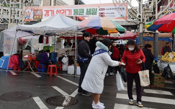 ▲ 경상원이 여주한글시장을 방문한 도민들에게 '통큰 세일' 홍보물을 나눠주고 있다.