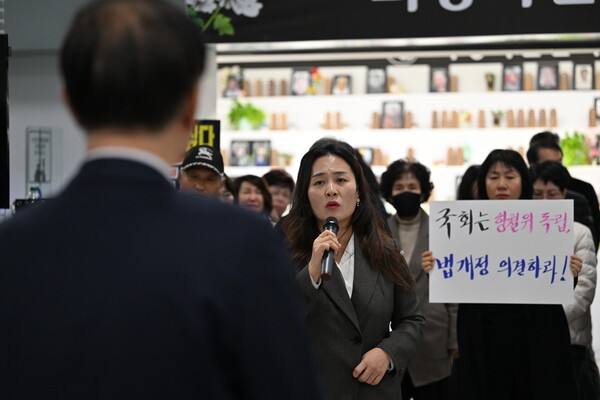 ▲ 김유진(가운데) 12·29 무안공항 제주항공 여객기 참사 유가족 협의회 대표가 26일 오후 전남 무안군 무안국제공항에서 김윤덕 국토부장관을 향해 국토부 항공철도조사위원회가 예고한 참사 조사 결과 공청회 개최 중단을 촉구하고 있다. /뉴시스