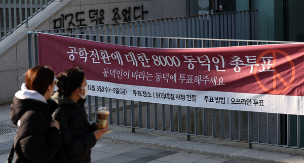 ▲ 동덕여자대학교 공학 전환 타당성에 대한 외부 용역 결과 발표와 '공학 전환에 대한 8000 동덕인 의견 조사' 학생 총투표가 실시되는 3일 서울 성북구 동덕여대에서 학생들이 총투표 관련 현수막 앞을 지나가고 있다. /뉴시스