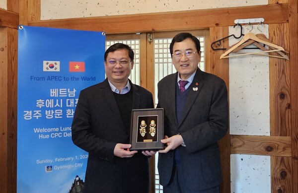 ▲ 주낙영 경주시장(오른쪽)이 2일 지역의 한 음식점에서 응우옌 타인 빈 베트남 후에중앙직할시 부시장과 기념품을 교환하며 기념촬영을 하고 있다.