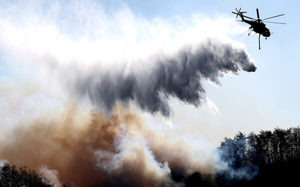 ▲ 8일 오후 경북 경주시 문무대왕면 입천리에서 발생한 산불이 강풍을 타고 확산되는 가운데 소방헬기가 진화 작업을 벌이고 있다. /뉴시스